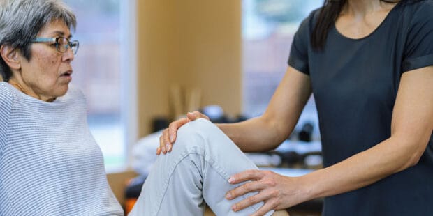 Therapist helping a resident with leg exercises