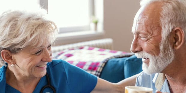 Caregiver and resident sharing a smile in an interior setting