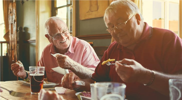 Two seniors enjoying a meal together in a cozy setting