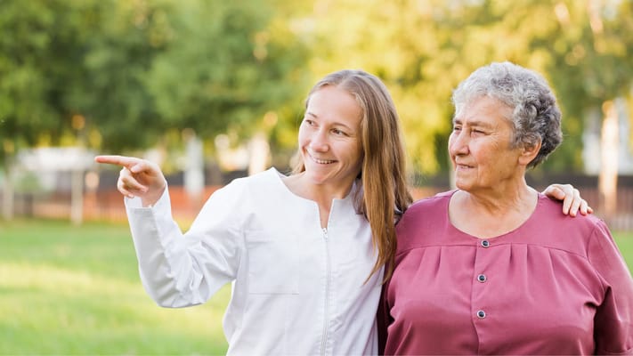 Staff member and resident enjoying time outside in a garden