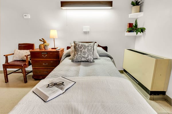 Cozy resident room with bed, chair, and nightstand