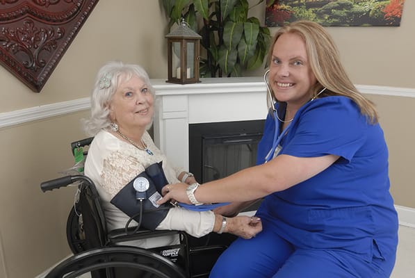 Nurse checking blood pressure of elderly resident
