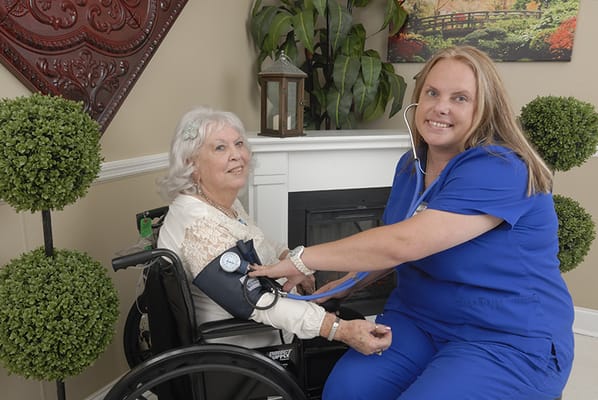 Nurse taking a resident's blood pressure in a warm setting