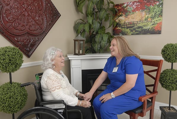 A resident and staff member enjoying a conversation indoors
