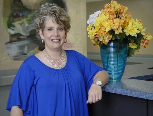 Staff member posing in a well-lit common area