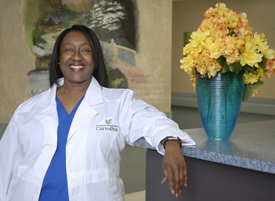 Staff member smiling in a healthcare facility lobby
