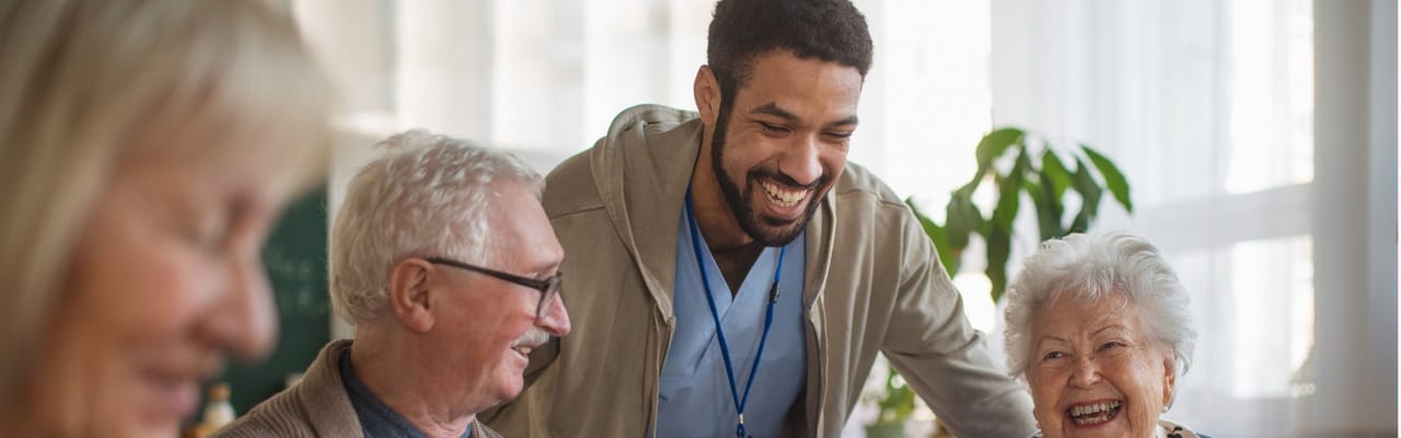Staff engaging with happy residents in a communal space