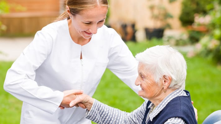 Staff member interacting with a resident in a garden