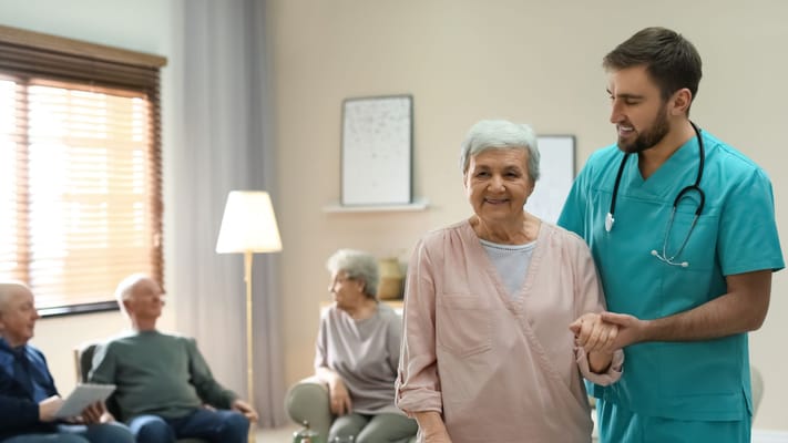 Staff assisting a resident in a common area