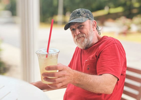 Senior resident enjoying a drink outdoors