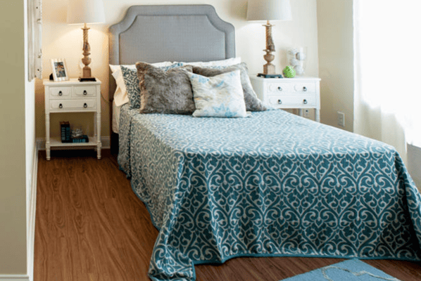 Brightly decorated single resident room with bed