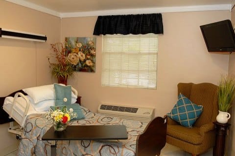 A cozy resident room with floral decor and seating area