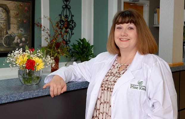 Staff member in a lobby area with flowers