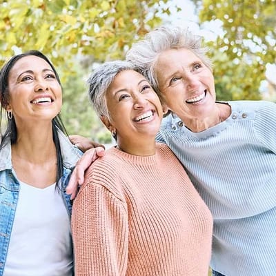 Three residents enjoying time outdoors under a tree