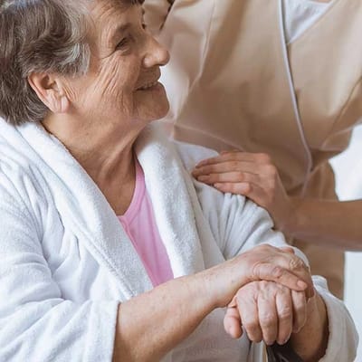 A smiling resident interacting with staff in a facility setting