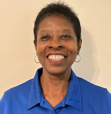 Staff member smiling in a blue uniform
