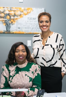 Two staff members smiling in an interior setting