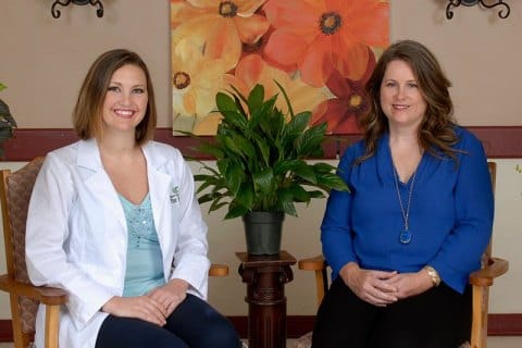 Two staff members posing in a bright indoor space.