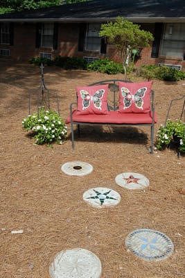 Outdoor seating area with butterfly pillows and decorative stones