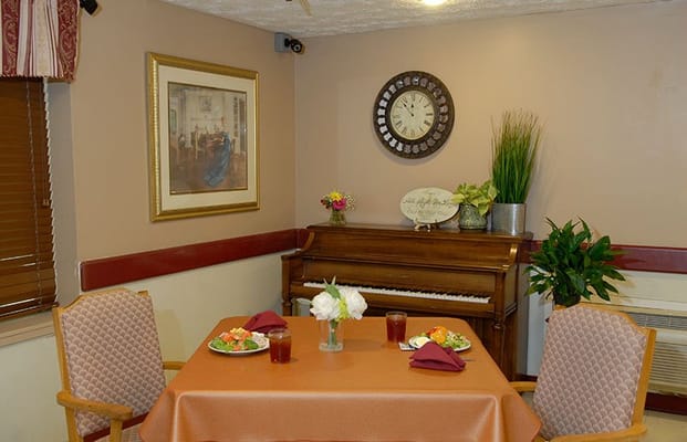 Dining area with a table set for two and a piano