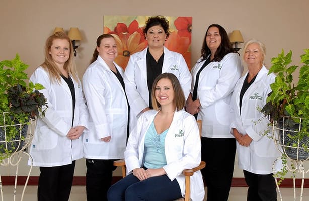 Six staff members in lab coats in a facility interior
