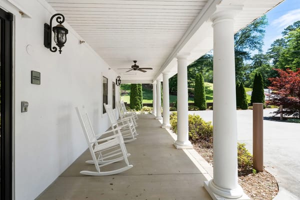 Rocking chairs lined up on a covered porch