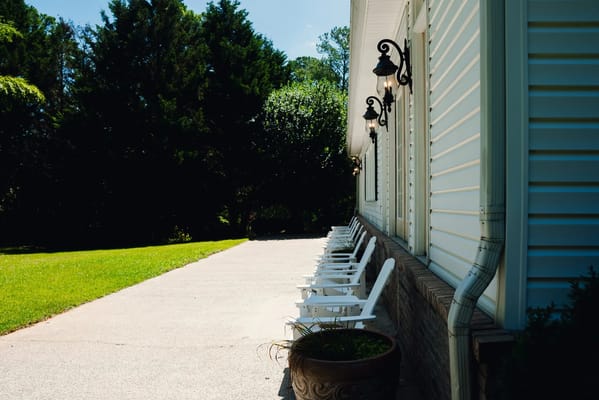 Outdoor seating area with white chairs and green lawn