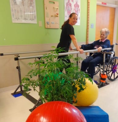 Staff assisting a resident during physical therapy