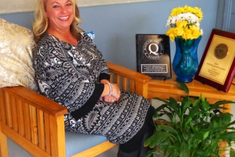 Staff member sitting in a cozy common area with flowers