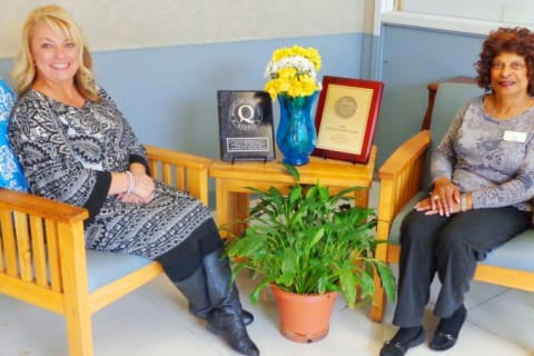 Two staff members posing in a lobby area