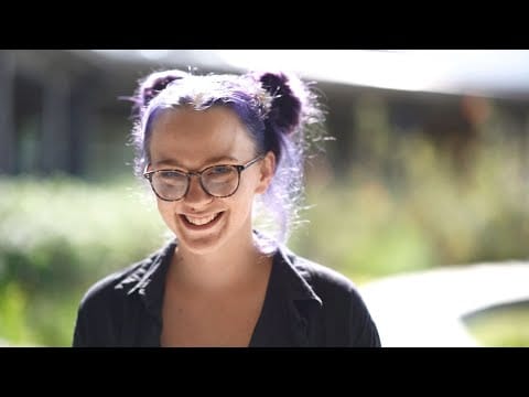 Young staff member smiling in a garden area