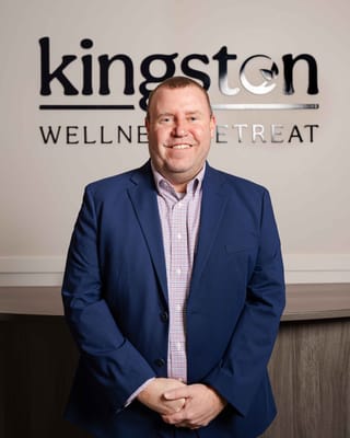 Staff member posing in front of the facility's name