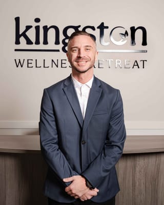 Staff member posing at the reception of Kingston Wellness Retreat