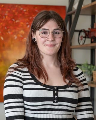 A staff member smiling in a cozy interior space