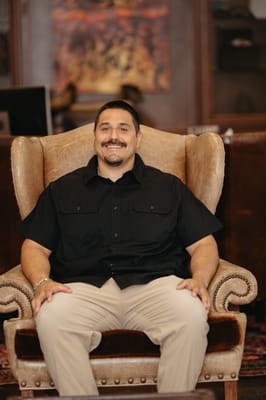 A man sitting in a large armchair in a lobby setting