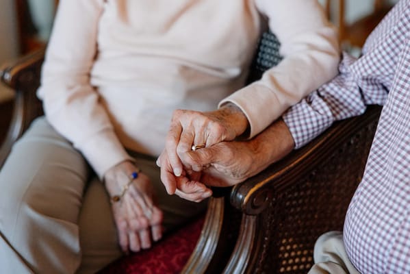 Two residents holding hands in a cozy setting