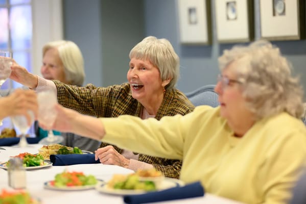 Residents enjoying a meal and toasting together
