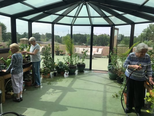 Residents tending to plants in a greenhouse