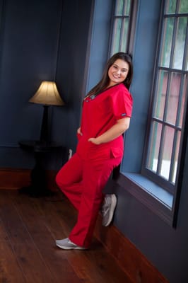 Nurse in scrubs posing in a well-lit interior