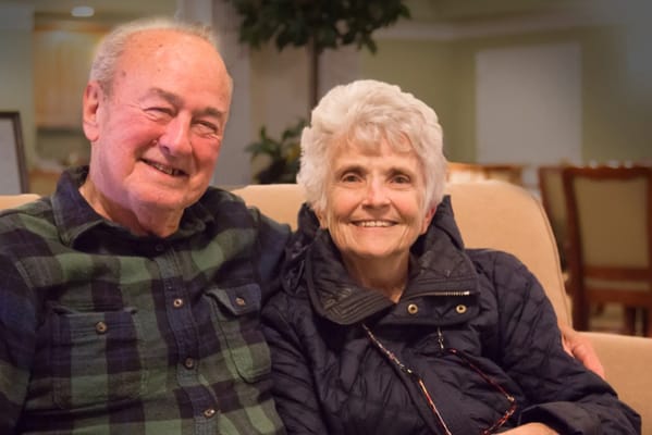 An elderly couple smiling together in a cozy setting