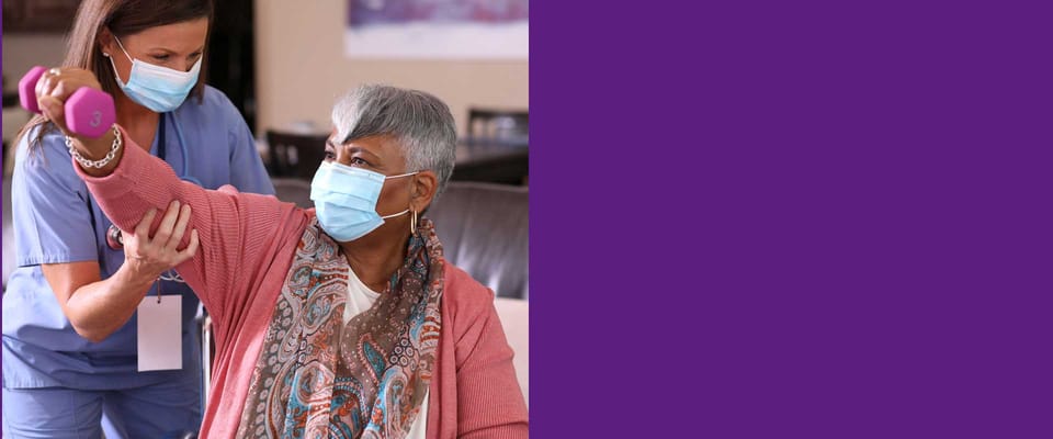 Resident exercising with staff assistance in a bright room