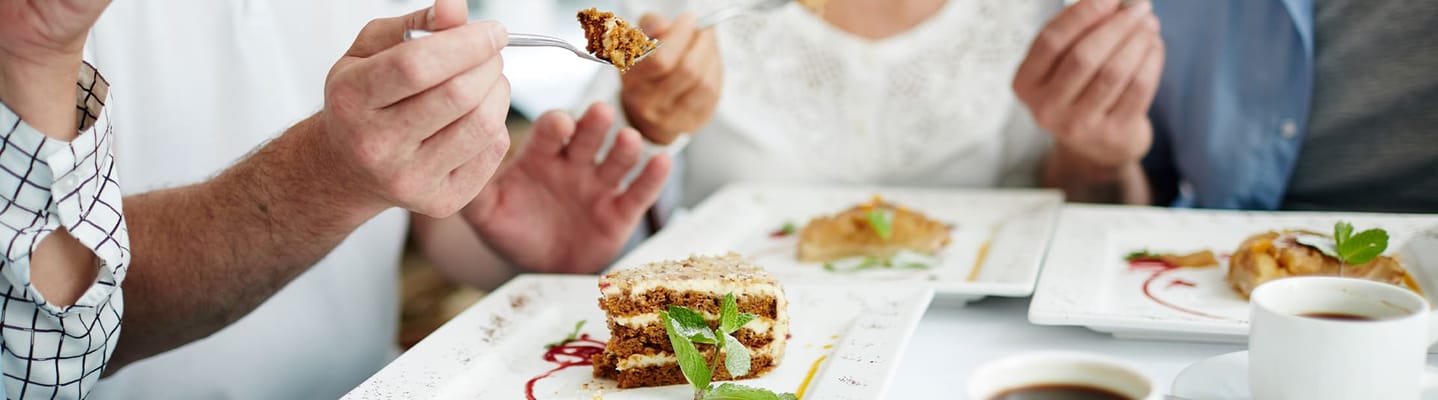 Residents enjoying dessert together at a dining table