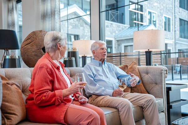 Two residents enjoying drinks in a cozy common area