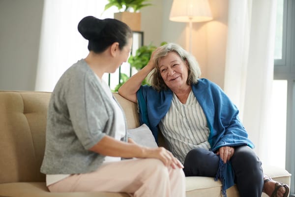 Two women engaged in conversation in a cozy lounge area