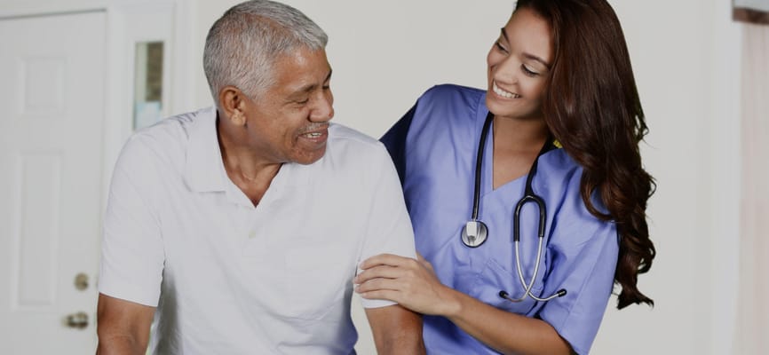 A caregiver smiling with a resident in a facility setting