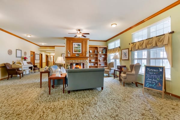 Common area with seating and bookshelves in a senior living facility