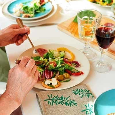 A resident enjoying a meal with salad and wine