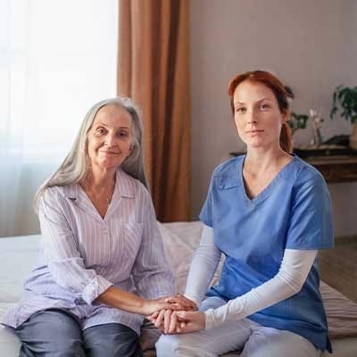 Caregiver and resident holding hands in a cozy room