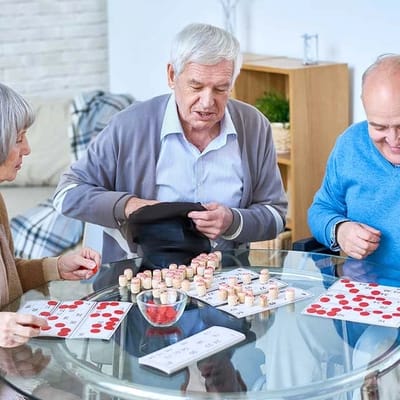 Residents playing bingo at a glass table