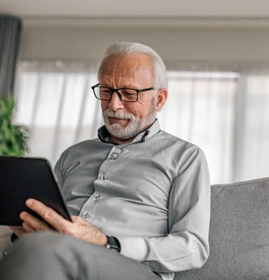 Senior man reading on a tablet in a cozy living space